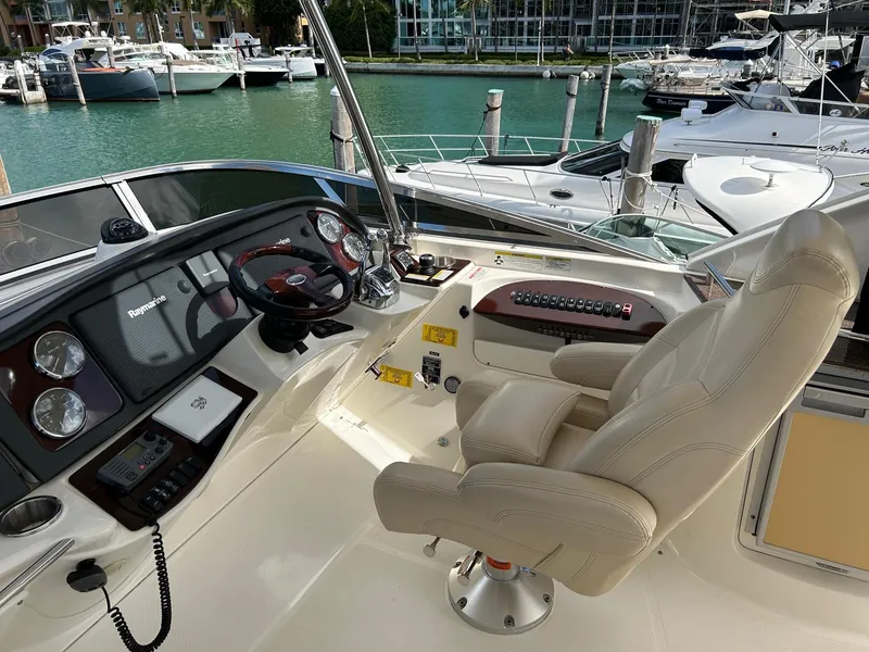 Slide: The Image of 2013 Meridian 441 yacht helm with luxurious seating and modern controls at marina. - 9