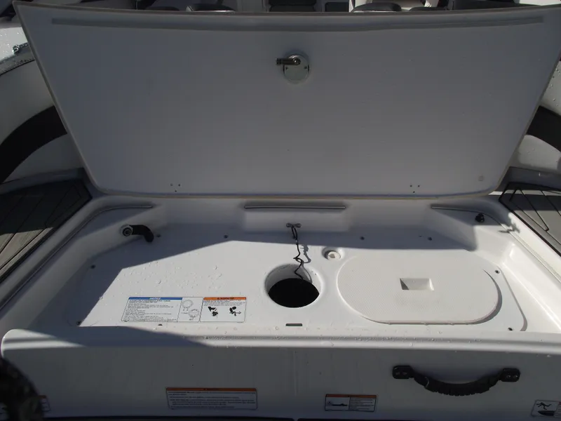 Slide: The Image of 2021 Yamaha AR195 boat storage compartment open, showcasing interior space and design. - 35