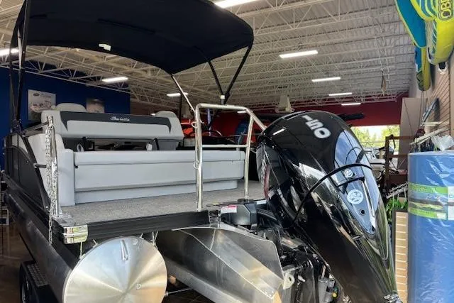 Slide: The Image of 2025 Barletta A22UC pontoon boat with outboard motor in showroom. - 2