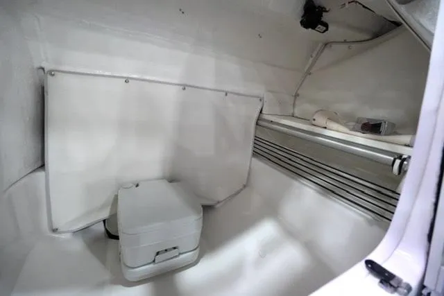 Slide: The Image of 2025 Bayliner T22SC interior cabin with compact toilet and storage space. - 10