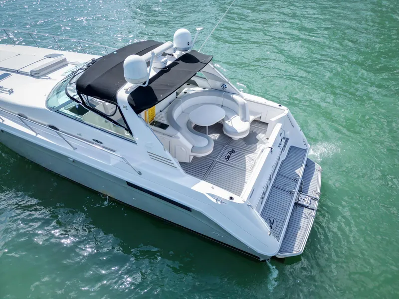 Slide: The Image of 1994 Sea Ray 500 Sundancer yacht on clear water, featuring spacious deck and seating area. - 14
