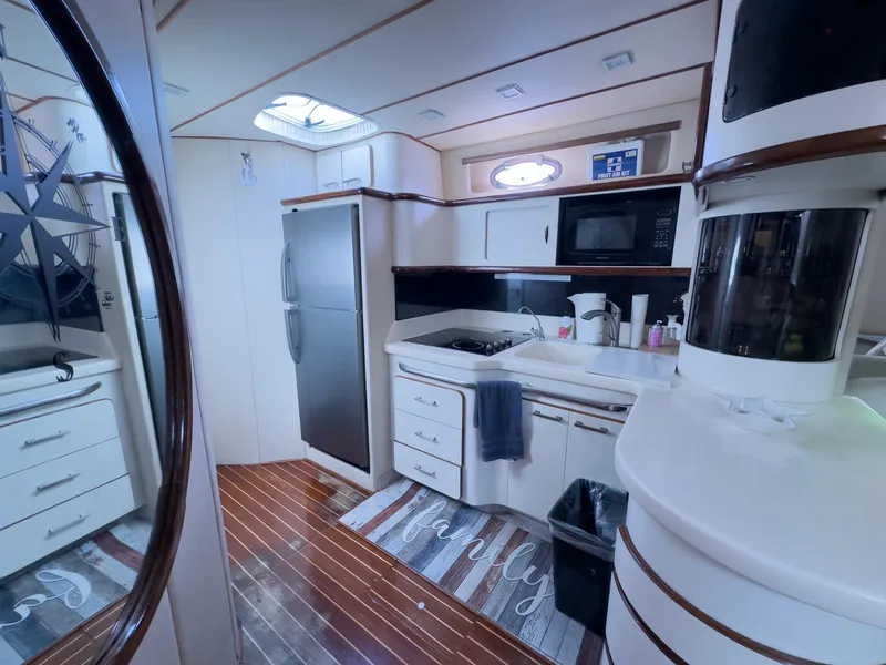 Slide: The Image of Interior of 1994 Sea Ray 500 Sundancer yacht kitchen with modern appliances and wood flooring. - 29