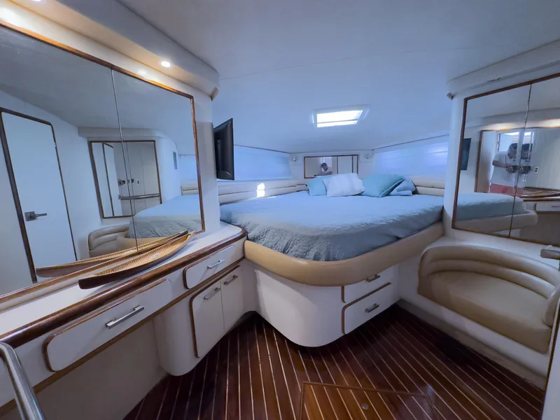 Slide: The Image of Luxurious 1994 Sea Ray 500 Sundancer cabin with elegant wood flooring and cozy bedding. - 33