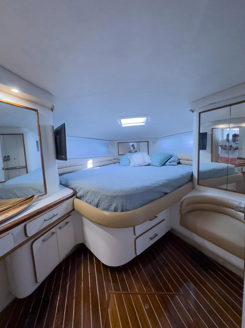 Slide: The Image of Luxurious 1994 Sea Ray 500 Sundancer cabin with elegant wood flooring and cozy bedding. - 38