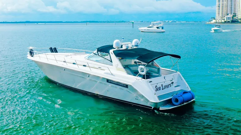 Slide: The Image of 1994 Sea Ray 500 Sundancer yacht on clear blue water, with city skyline in background. - 9