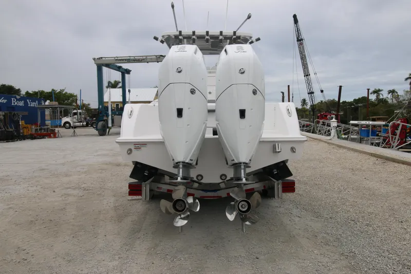 Slide: The Image of 2025 Invincible 33 Open Fisherman boat with dual outboard engines at a dockyard. - 12