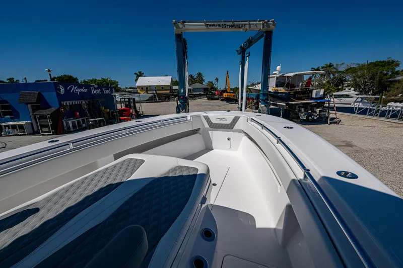 Slide: The Image of 2025 Invincible 33 Open Fisherman boat at a marina, showcasing spacious deck design. - 15