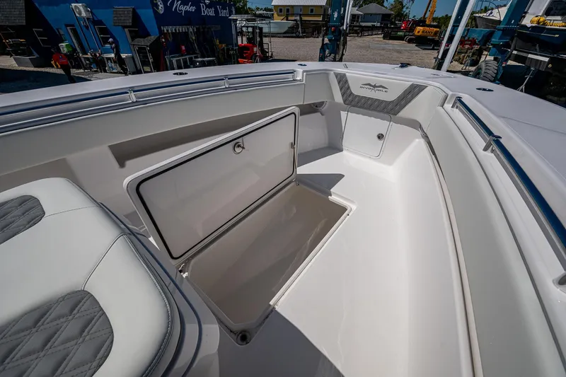 Slide: The Image of 2025 Invincible 33 Open Fisherman boat with open storage compartment, white interior, and cushioned seating. - 17