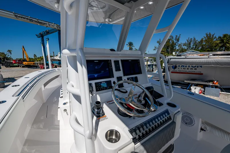 Slide: The Image of 2025 Invincible 33 Open Fisherman boat cockpit with modern controls and dual screens. - 38