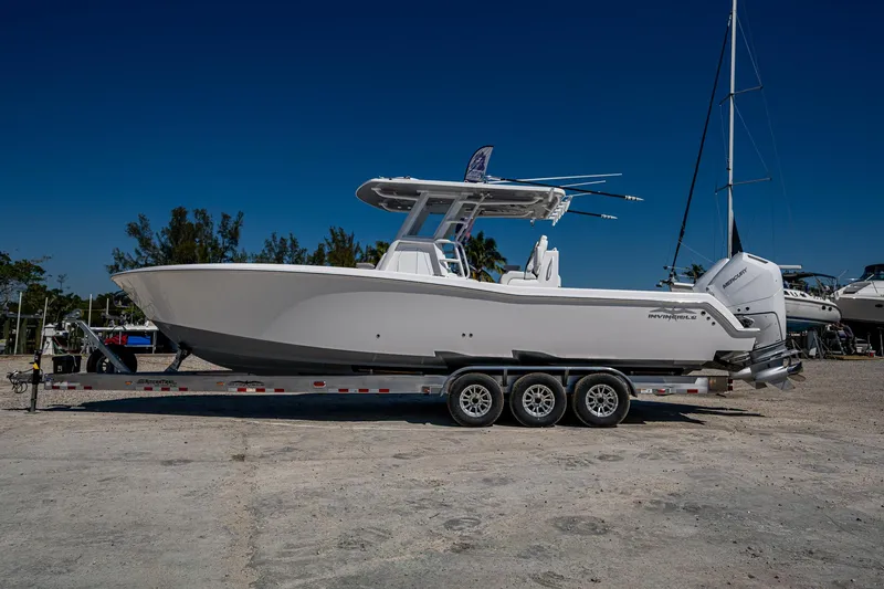 Slide: The Image of 2025 Invincible 33 Open Fisherman boat on trailer, side view, clear sky background. - 43
