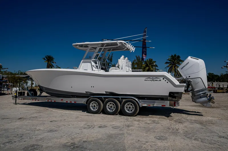 Slide: The Image of 2025 Invincible 33 Open Fisherman boat on trailer, parked outdoors under clear blue sky. - 44
