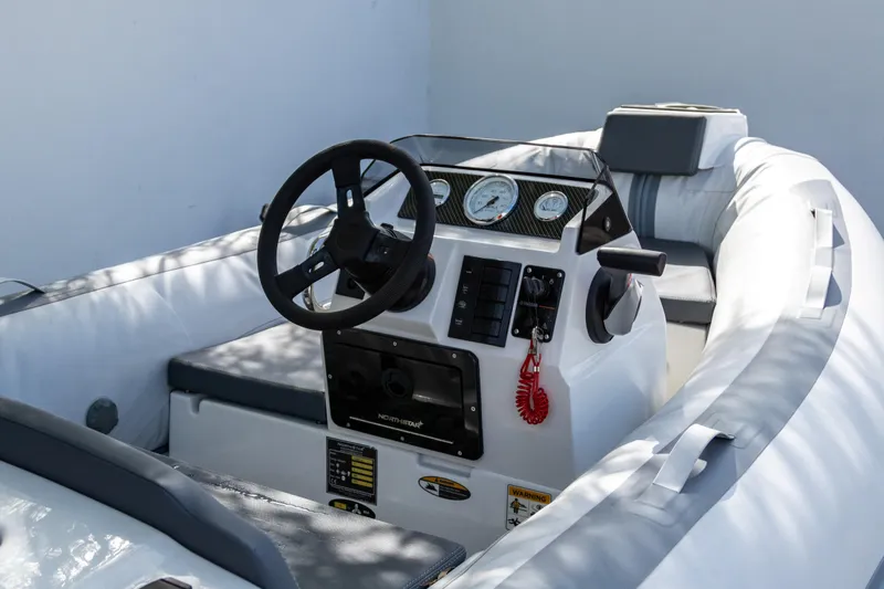Slide: The Image of 2021 Northstar Axis 3.1 boat interior with steering wheel and control panel. - 2
