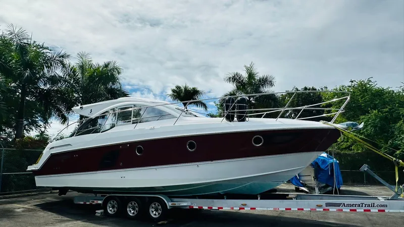 The Image of 2013 Beneteau GRAN TURISMO yacht on trailer, surrounded by palm trees, under cloudy sky. - 1