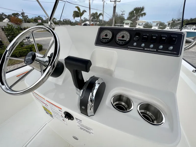 Slide: The Image of 2025 Boston Whaler 190 Montauk boat console with steering wheel and controls. - 10