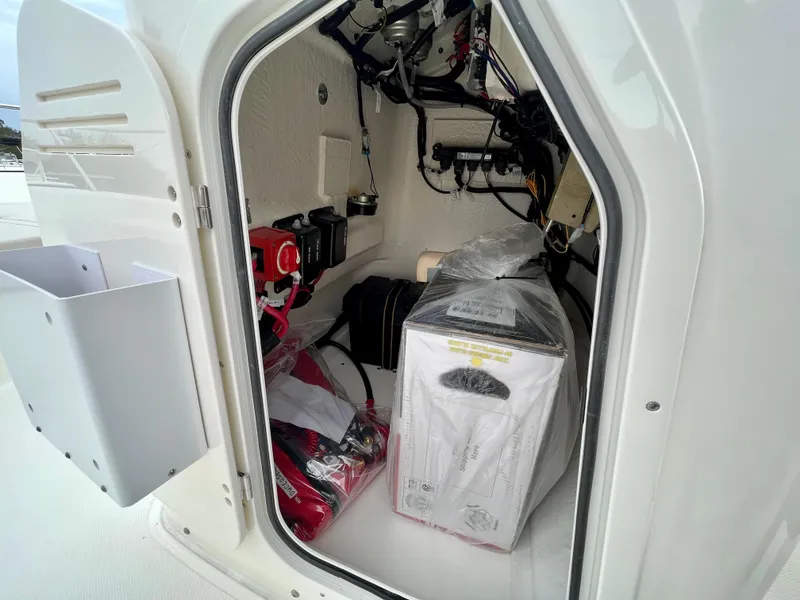 Slide: The Image of Storage compartment of 2025 Boston Whaler 190 Montauk boat, featuring equipment and wiring. - 16