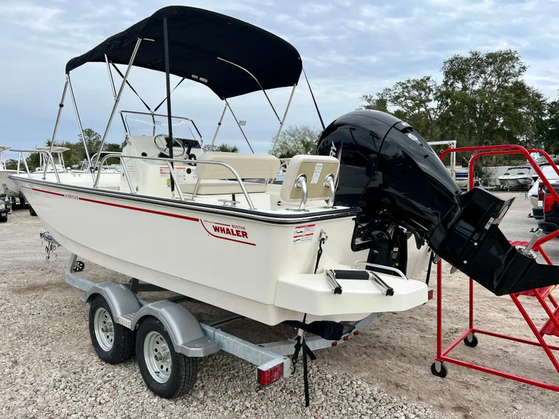 Slide: The Image of 2025 Boston Whaler 190 Montauk boat on trailer with canopy and outboard motor. - 6