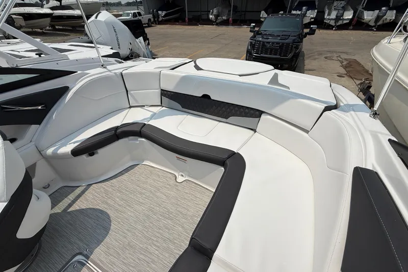 Slide: The Image of 2025 Monterey 224FS boat interior with sleek white and black seating, docked outdoors. - 10