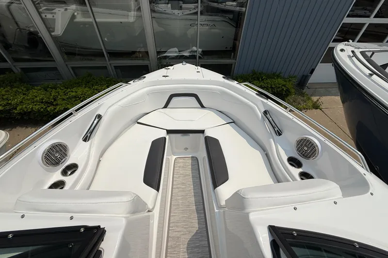 Slide: The Image of 2025 Monterey 224FS boat interior with white seating and speakers, docked near a building. - 7