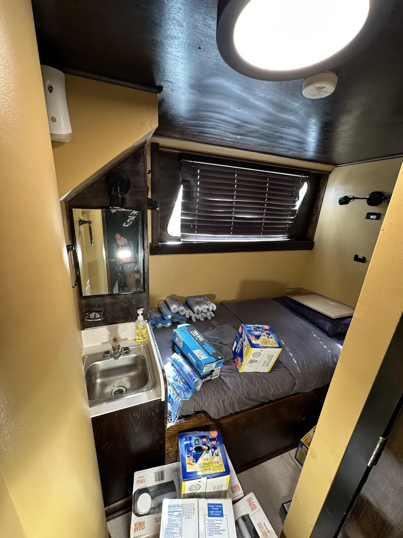 Slide: The Image of Small cabin interior on a 1965 custom dive boat with bed, sink, and supplies. - 12
