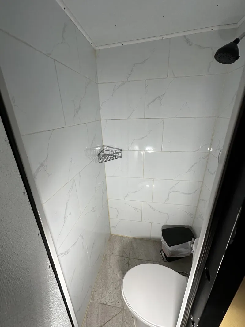 Slide: The Image of Compact bathroom with white tiled walls on a 1965 custom dive boat. - 13