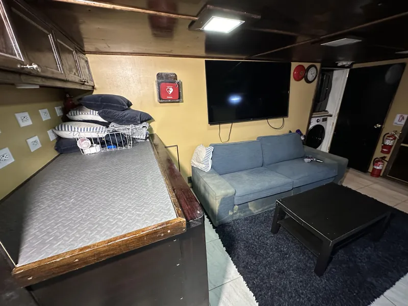 Slide: The Image of Interior of a 1965 custom dive boat with sofa, TV, and storage. - 18