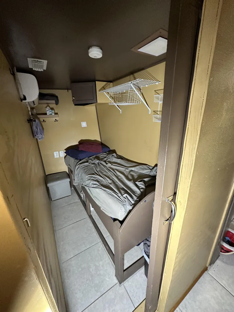 Slide: The Image of Small cabin interior on a 1965 custom dive boat with a single bed and storage shelves. - 22