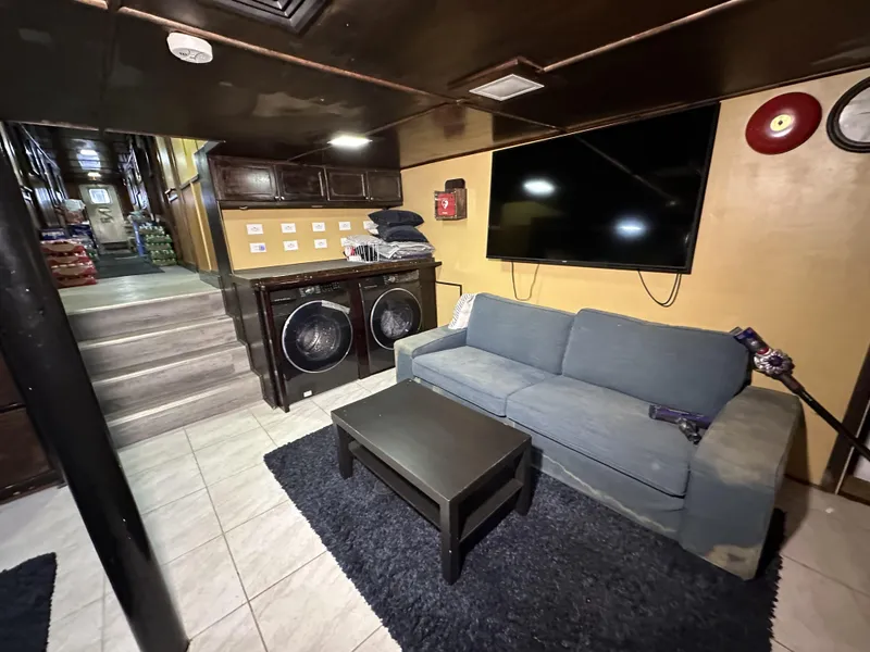 Slide: The Image of Interior of a 1965 custom dive boat with sofa, TV, and laundry area. - 25