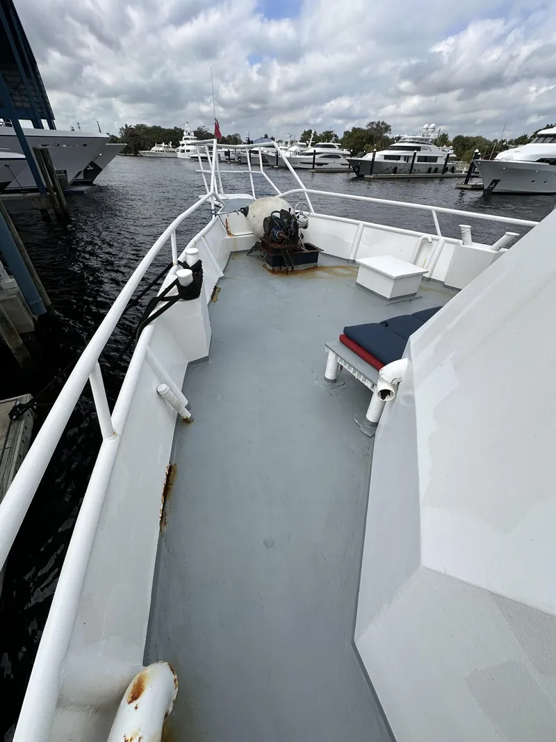 Slide: The Image of 1965 Custom Dive Boat deck with seating, docked at marina under cloudy skies. - 27