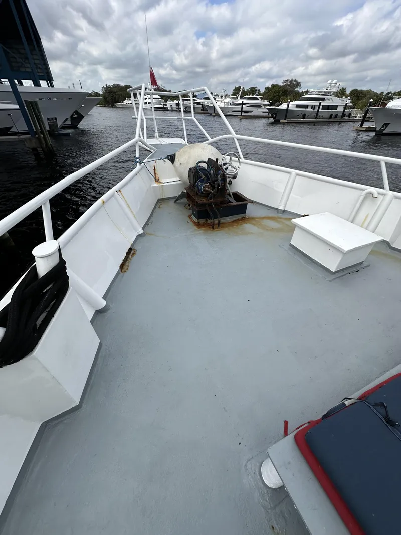 Slide: The Image of 1965 Custom Dive Boat deck with railing, docked at marina under cloudy sky. - 28