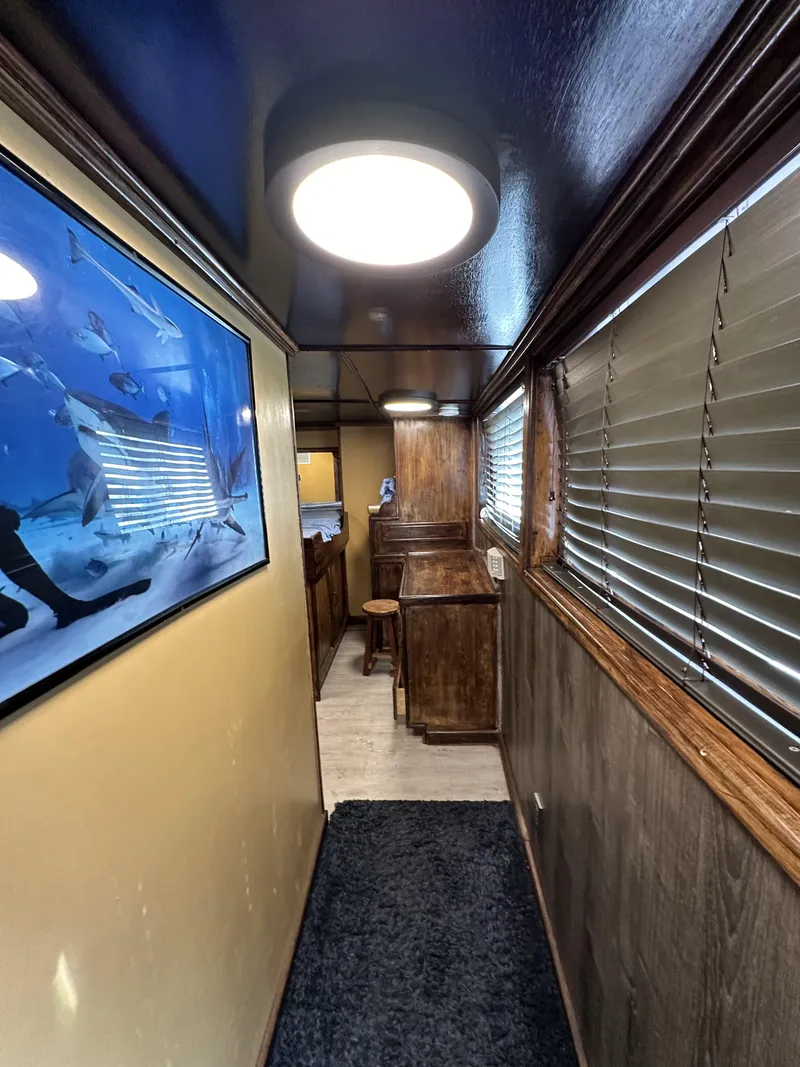 Slide: The Image of Interior hallway of a 1965 custom dive boat with wood paneling and marine artwork. - 33