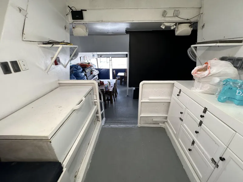 Slide: The Image of Interior of a 1965 custom dive boat with white cabinetry and dining area. - 43