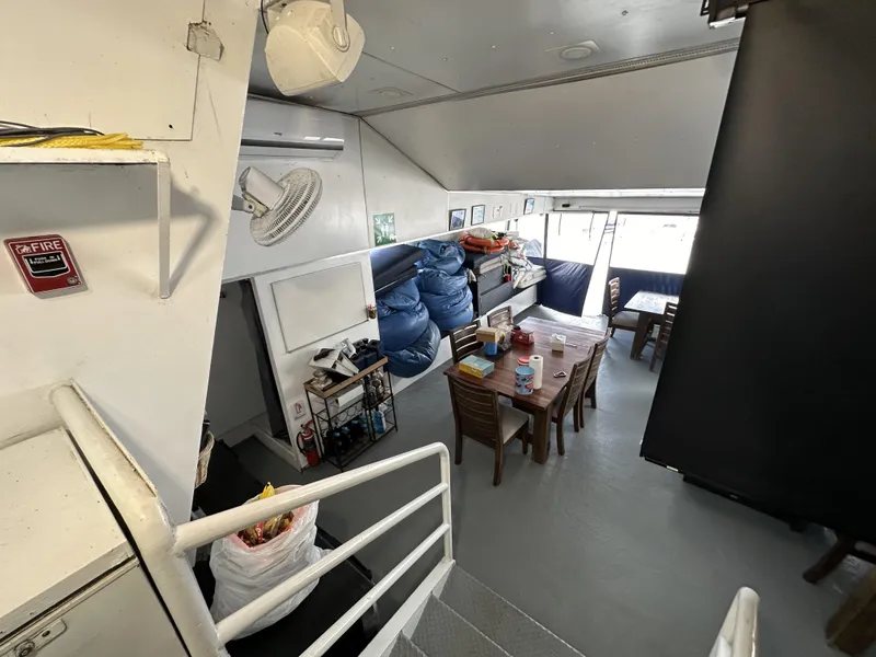 Slide: The Image of Interior of a 1965 custom dive boat with tables, chairs, and equipment storage. - 44