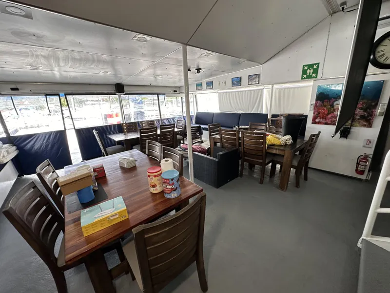 Slide: The Image of Interior of a 1965 custom dive boat with dining tables and seating area. - 46