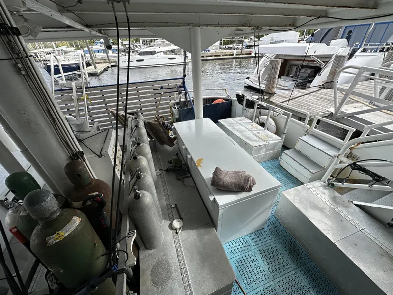 Slide: The Image of 1965 custom dive boat interior with scuba tanks and equipment, docked at a marina. - 6