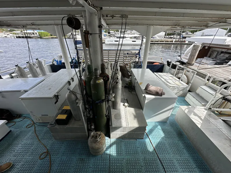 Slide: The Image of 1965 Custom Dive Boat interior with equipment, docked at marina, featuring tanks and seating area. - 8