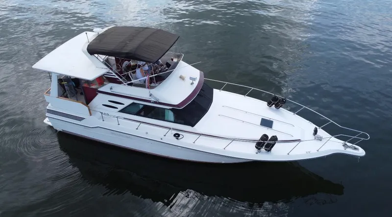 Slide: The Image of 1989 Sea Ray 440 Aft Cabin yacht on calm water, aerial view. - 1