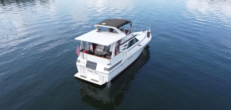 Slide: The Image of 1989 Sea Ray 440 Aft Cabin yacht on calm water, rear view. - 2