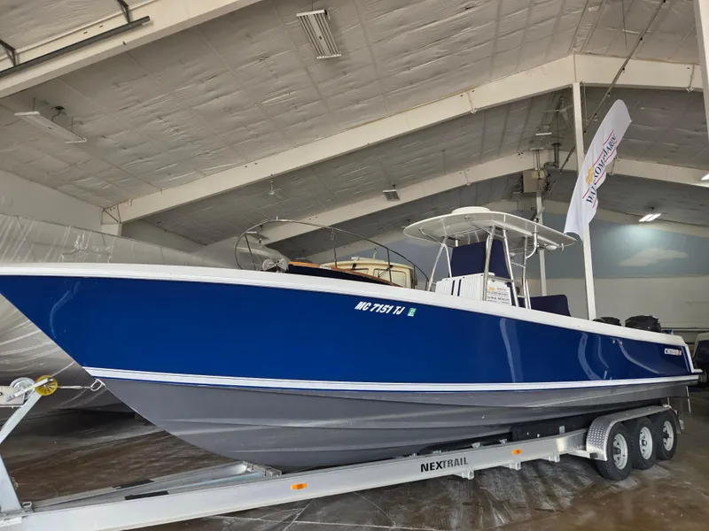 The Image of 2008 Contender 33 Tournament boat in blue, displayed indoors on a trailer. - 0