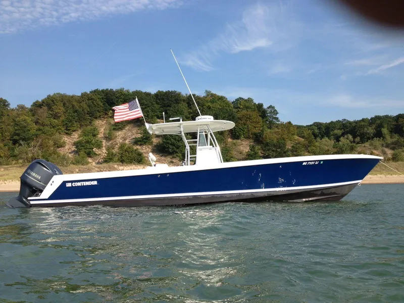 Slide: The Image of 2008 Contender 33 Tournament boat on water with American flag, scenic shoreline background. - 1