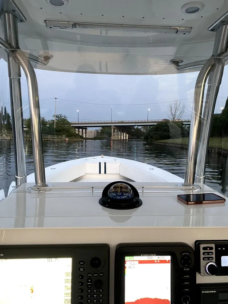 Slide: The Image of 2008 Contender 33 Tournament boat cockpit view with navigation equipment, approaching a bridge. - 16
