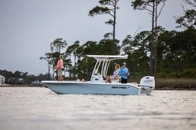 Slide: The Image of 2025 Sea Pro 202 Center Console boat on water with people fishing, surrounded by trees. - 4