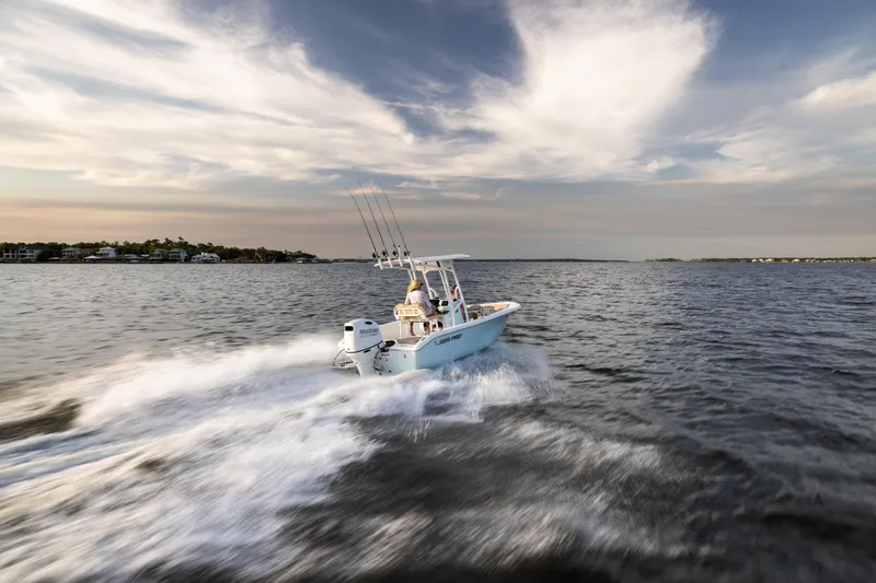 Slide: The Image of 2025 Sea Pro 202 Center Console boat cruising on open water under a cloudy sky. - 5