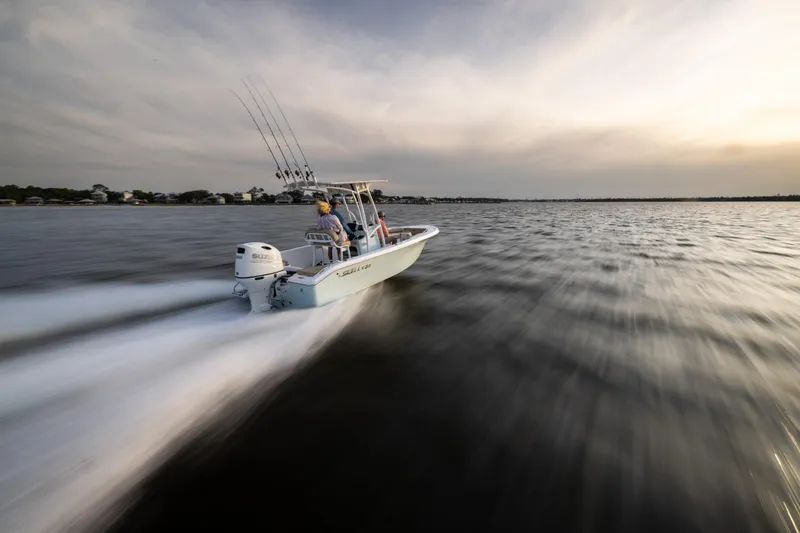 Slide: The Image of 2025 Sea Pro 202 Center Console boat speeding on open water at sunset. - 7