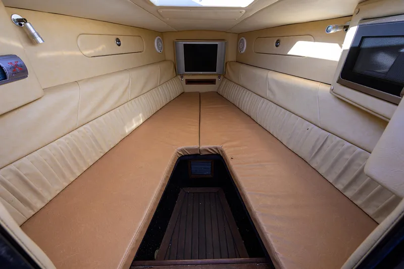 Slide: The Image of Interior cabin of 2005 Midnight Express 39S Open boat, featuring beige upholstery and a skylight. - 34
