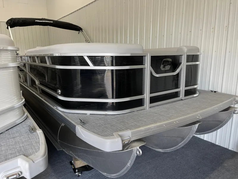 Slide: The Image of 2025 Princecraft Vectra 25 RL pontoon boat in storage, featuring sleek black and silver design. - 15