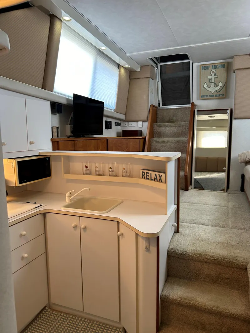 Slide: The Image of Interior of 1993 Silverton 34 Aft Cabin Motor Yacht with modern kitchen and cozy living area. - 12