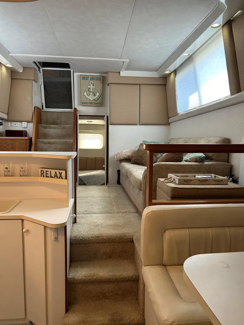 Slide: The Image of Interior of 1993 Silverton 34 Aft Cabin Motor Yacht, featuring cozy seating and modern decor. - 13