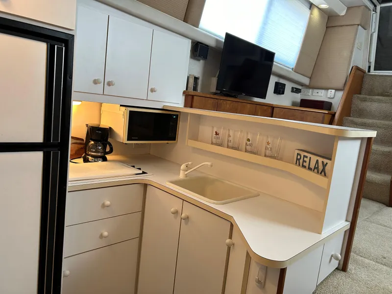Slide: The Image of Interior of 1993 Silverton 34 Aft Cabin Motor Yacht kitchen with sink, microwave, and coffee maker. - 15