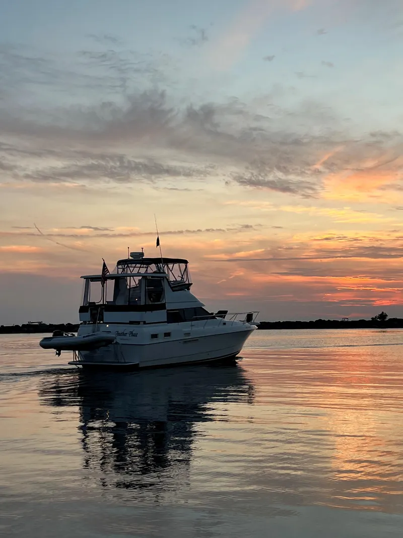 Slide: The Image of 1993 Silverton 34 Aft Cabin Motor Yacht at sunset on calm waters. - 2