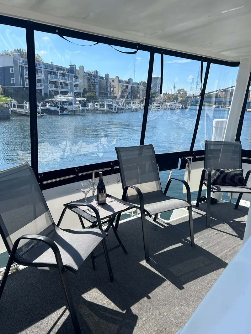 Slide: The Image of 1993 Silverton 34 Aft Cabin Motor Yacht interior with chairs and table overlooking marina. - 22